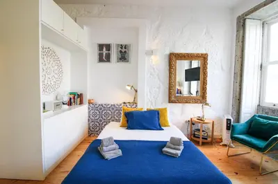 a bedroom with a blue bed and a mirror at Historic Oldtown Getaway in Porto