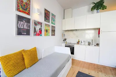 a kitchen with white cabinets and a couch in a room at Historic Oldtown Getaway in Porto
