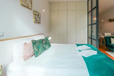 a bedroom with a white bed with towels on it at Aliados Sunny Flat in Porto