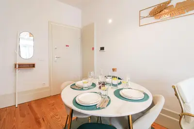 a white dining room with a white table and chairs at Aliados Sunny Flat in Porto