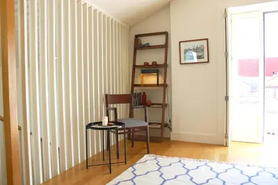 a room with a chair and a table and a window at Amazing Flores Duplex in Porto