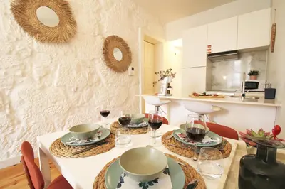 a kitchen with a table with plates and glasses of wine at Cativo Design Apartment in Porto