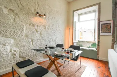 a dining room with a glass table and chairs at Cativo Mezzanine Loft in Porto