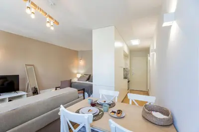 a living room with a couch and a table and chairs at Cosy Flat Near Douro in Porto