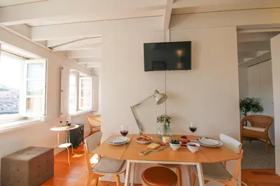 a living room with a table and a tv on the wall at Douro Dreams in Porto