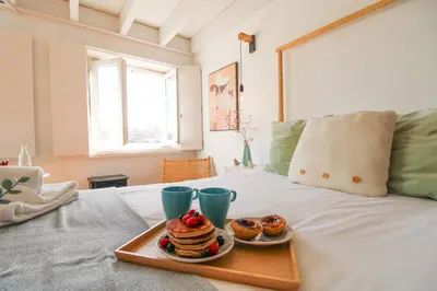 a tray of pancakes and donuts on a bed at Douro Dreams in Porto