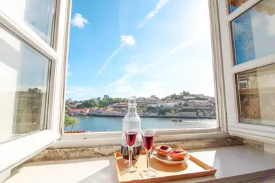 two glasses of wine and donuts in front of a window at Douro Dreams in Porto