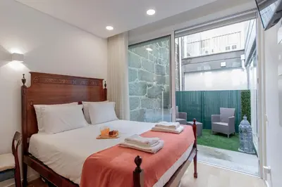a bedroom with a bed with two towels on it at Cozy Studio w/ Patio by LovelyStay in Porto
