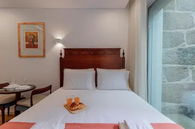 a bed with a pair of shoes sitting on it at Cozy Studio w/ Patio by LovelyStay in Porto