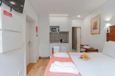 a bedroom with a bed with a red blanket on it at Cozy Studio w/ Patio by LovelyStay in Porto
