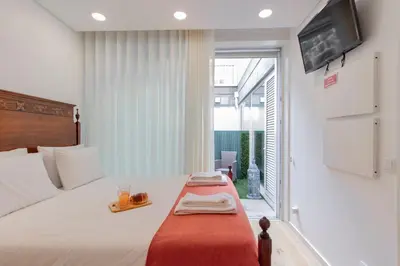 a bedroom with a bed with a tray on it at Cozy Studio w/ Patio by LovelyStay in Porto