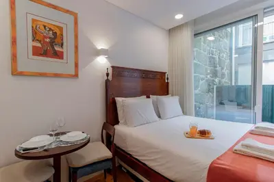 a bedroom with a bed and a table and a window at Cozy Studio w/ Patio by LovelyStay in Porto