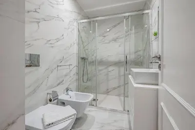 a kitchen with white cabinets and a dining room at Almada Glamorous & Chic Oporto Downtown in Porto