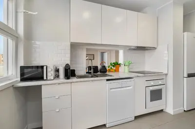 a white kitchen with white cabinets and a microwave at WHome FT169 Top Location 2-Bed Perfect to explore Porto in Porto