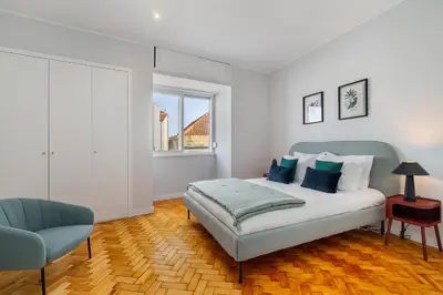 a bedroom with a bed and a chair and a window at WHome FT169 Top Location 2-Bed Perfect to explore Porto in Porto