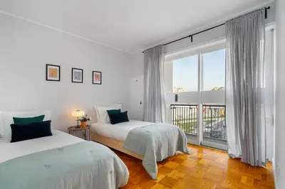 a white bedroom with two beds and a large window at WHome FT169 Top Location 2-Bed Perfect to explore Porto in Porto