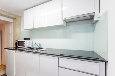 a white kitchen with a sink and a microwave at Almada Hideaway w/ AC & Private Pool by LovelyStay in Porto