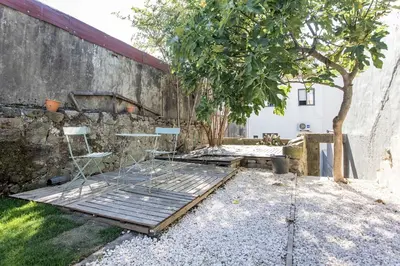 a patio with a table and chairs and a tree at Almada Hideaway w/ AC & Private Pool by LovelyStay in Porto