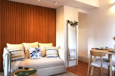a living room with a couch and a table at Living Aliados Mezzanine Flat W/ AC in Porto