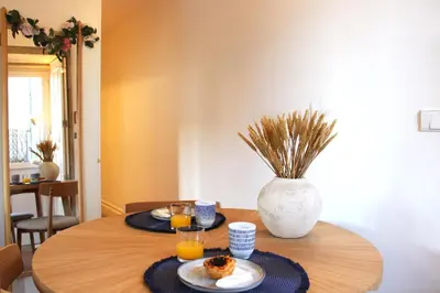 a table with two plates of food and a vase at Living Aliados Mezzanine Flat W/ AC in Porto