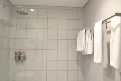 a bathroom with a shower with white towels at Living Aliados Mezzanine Flat W/ AC in Porto
