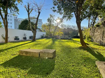 a bench in a park with trees and a building at LovePorto2 Balcony/Garden@Hist.C in Porto