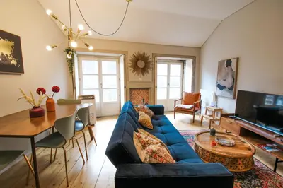 a living room with a blue couch and a table at Virtudes Irresistible Getaway in Porto