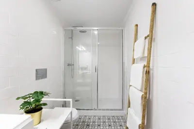 a white bathroom with a shower and a toilet at São Bento Premium Loft - With Air Conditioning in Porto