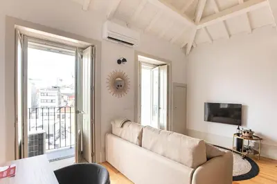 a living room with a couch and a large window at São Bento Premium Loft - With Air Conditioning in Porto