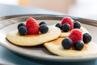 a plate topped with fruit on top of pancakes at São Bento Premium Loft - With Air Conditioning in Porto