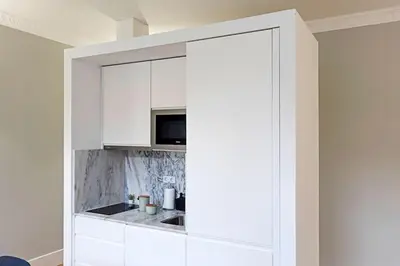 a kitchen with white cabinets and a microwave at Historical Sunny Marquês - With AC! in Porto