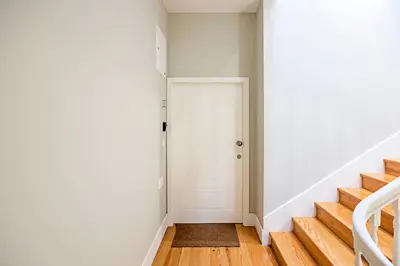 a hallway with a white door and stairs at Historical Sunny Marquês - With AC! in Porto