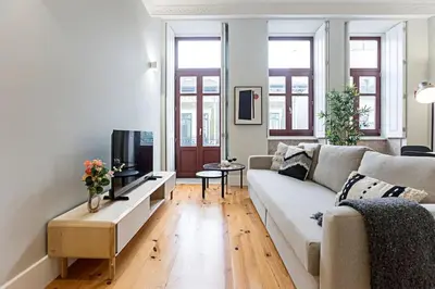 a living room with a couch and a tv at Historical Sunny Marquês - With AC! in Porto