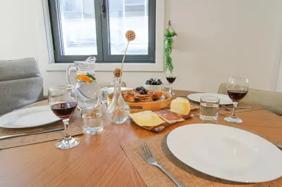 a table with glasses of wine and a bowl of food at Porto Trindade Triplex in Porto