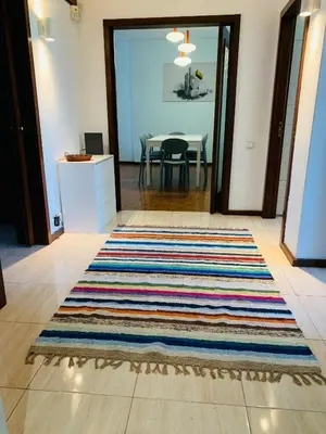 a room with a rug on the floor with a table at Bairro das arts in Porto