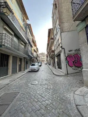 a car is parked on a cobblestone street at Caldeireiros Lovely Suite by Porto City Hosts in Porto