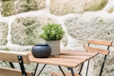 a black vase sitting on a wooden table with a plant at GuestReady - Studio in Porto in Porto
