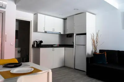 a small kitchen with white cabinets and a table at Almada Downtown 203 in Porto