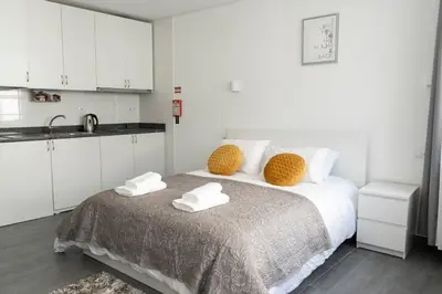 a white bedroom with a bed with towels on it at Almada Downtown 301 in Porto
