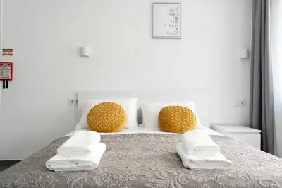a bed with two pillows and towels on it at Almada Downtown 301 in Porto