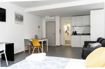 a living room with a table and a kitchen at Almada Downtown 303 in Porto