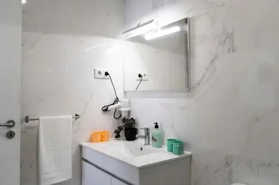 a white bathroom with a sink and a mirror at Almada Downtown 304 in Porto