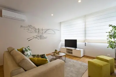 a living room with a couch and a tv at APOSENTUS - Marta's House in Porto