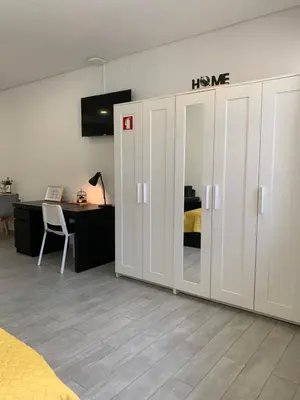 a bedroom with white cabinets and a desk and a bed at Almada Downtown 402 in Porto