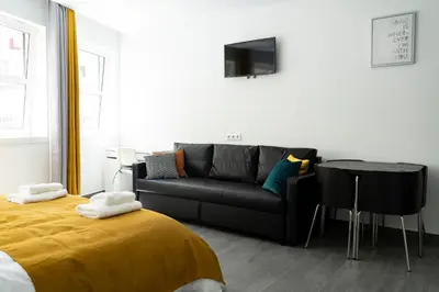 a living room with a black couch and a table at Almada Downtown 101 in Porto