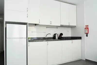 a kitchen with white cabinets and a sink at Almada Downtown 101 in Porto