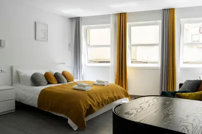 a bedroom with a bed and two windows at Almada Downtown 101 in Porto