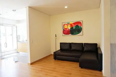 a living room with a couch and a painting on the wall at Tomás Flat in Porto