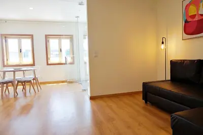a living room with a couch and a table and chairs at Tomás Flat in Porto