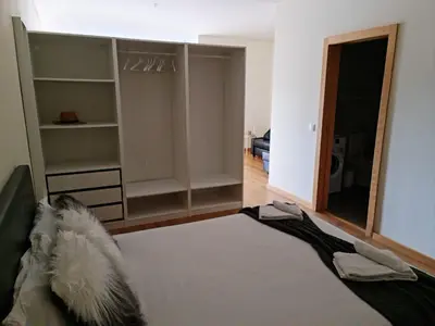 a room with a bed and a closet with a mirror at Tomás Flat in Porto